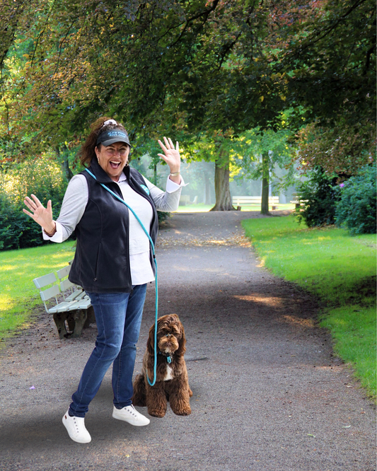 Happy woman and dog walking on leash in park